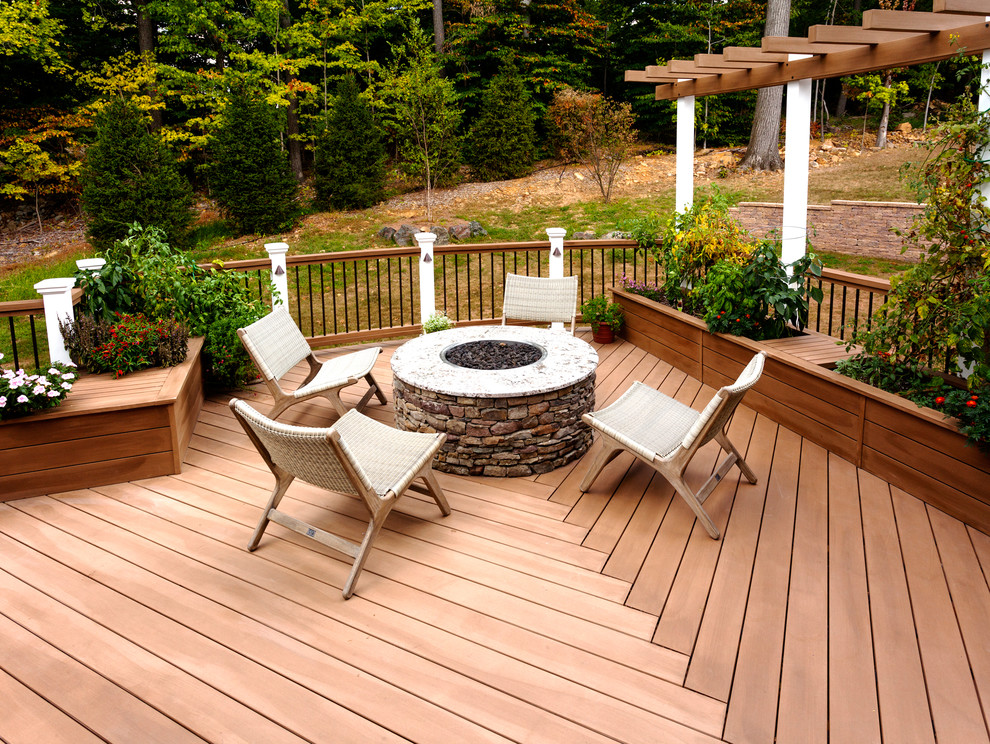 Large transitional backyard deck in New York with no cover and a fire feature.