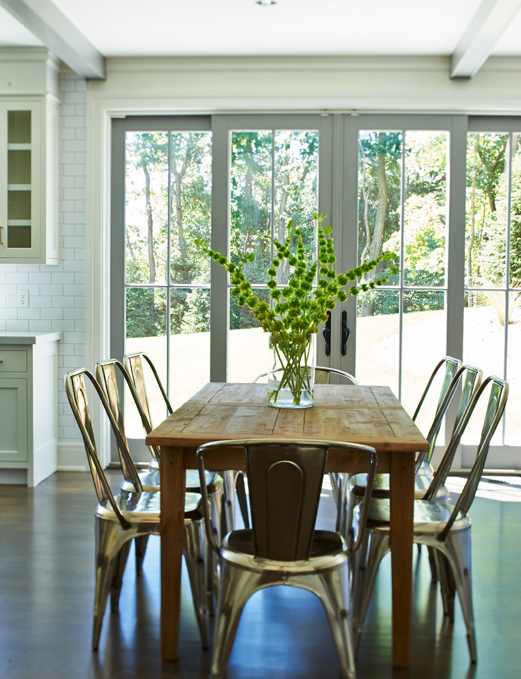 This is an example of a country kitchen/dining combo in New York with white walls and dark hardwood floors.