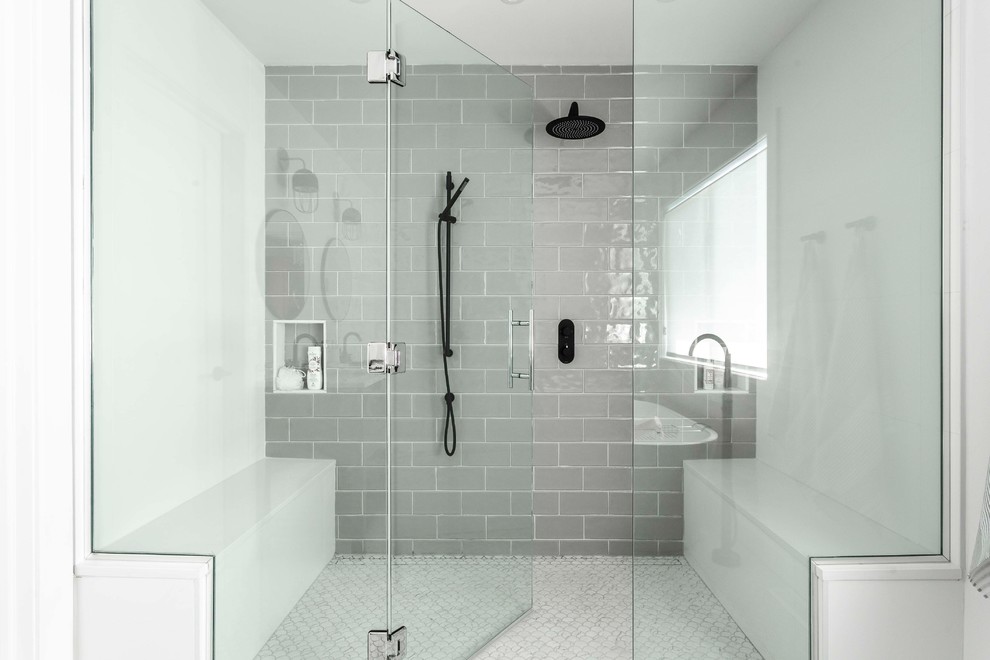 This is an example of a large contemporary master bathroom in Montreal with furniture-like cabinets, grey cabinets, a freestanding tub, gray tile, white walls, mosaic tile floors, an undermount sink, marble benchtops, white floor, a hinged shower door, a curbless shower, a bidet, subway tile and white benchtops.