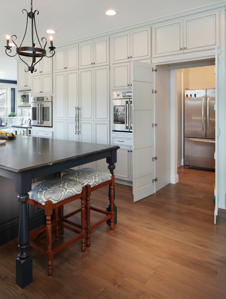 Design ideas for a traditional kitchen in Denver with recessed-panel cabinets, with island, white cabinets, soapstone benchtops and black benchtop.