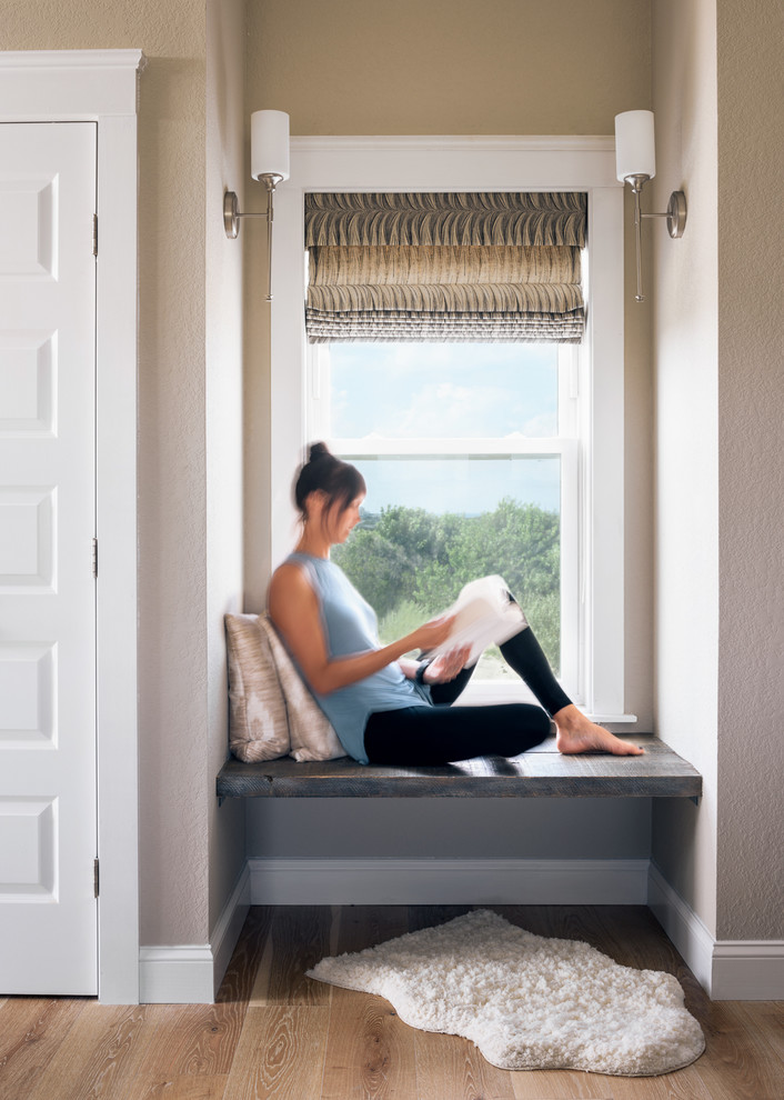 Example of a mid-sized minimalist master light wood floor and brown floor bedroom design in Other with beige walls and a two-sided fireplace