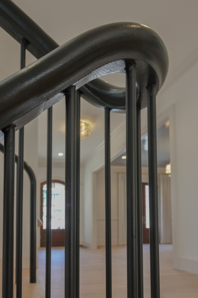 На фото: большая п-образная лестница в стиле модернизм с деревянными ступенями, крашенными деревянными подступенками, перилами из смешанных материалов и панелями на стенах с