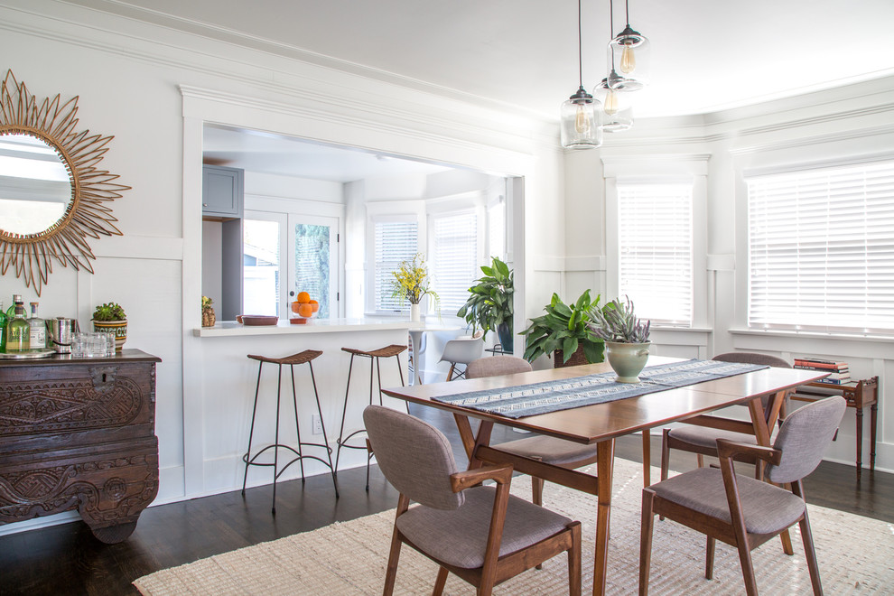 Photo of a transitional dining room in Los Angeles with white walls, dark hardwood floors and brown floor.