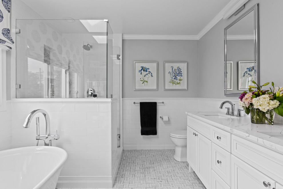 Design ideas for a medium sized classic ensuite bathroom in Chicago with shaker cabinets, white cabinets, a freestanding bath, a corner shower, a one-piece toilet, white tiles, metro tiles, grey walls, mosaic tile flooring, a wall-mounted sink, engineered stone worktops, grey floors, a hinged door, white worktops, a wall niche, double sinks and a freestanding vanity unit.