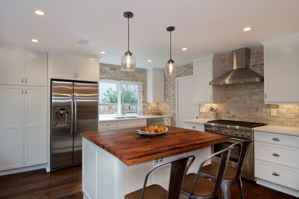 Inspiration for a mid-sized country l-shaped open plan kitchen in San Diego with an undermount sink, shaker cabinets, white cabinets, quartz benchtops, white splashback, stainless steel appliances, dark hardwood floors, with island and brick splashback.