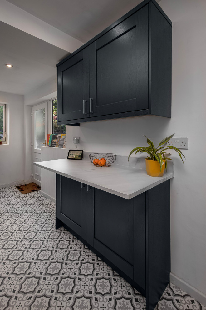 Contemporary grey and white kitchen in Other with a built-in sink, shaker cabinets, grey cabinets, laminate countertops, white splashback, glass sheet splashback, integrated appliances, porcelain flooring, no island, multi-coloured floors and white worktops.