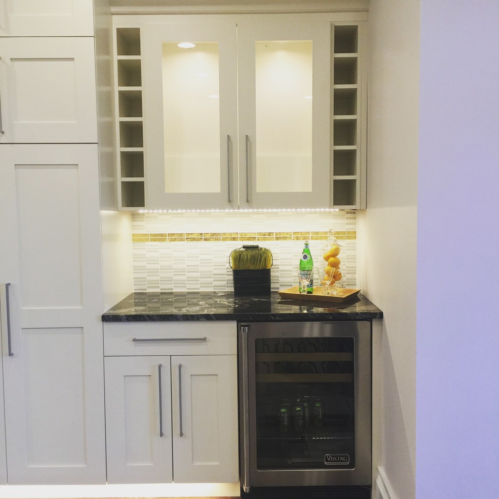 Inspiration for a mid-sized transitional u-shaped light wood floor and beige floor eat-in kitchen remodel in Boston with white cabinets, granite countertops, recessed-panel cabinets, a farmhouse sink, beige backsplash, stone tile backsplash, stainless steel appliances, an island and multicolored countertops