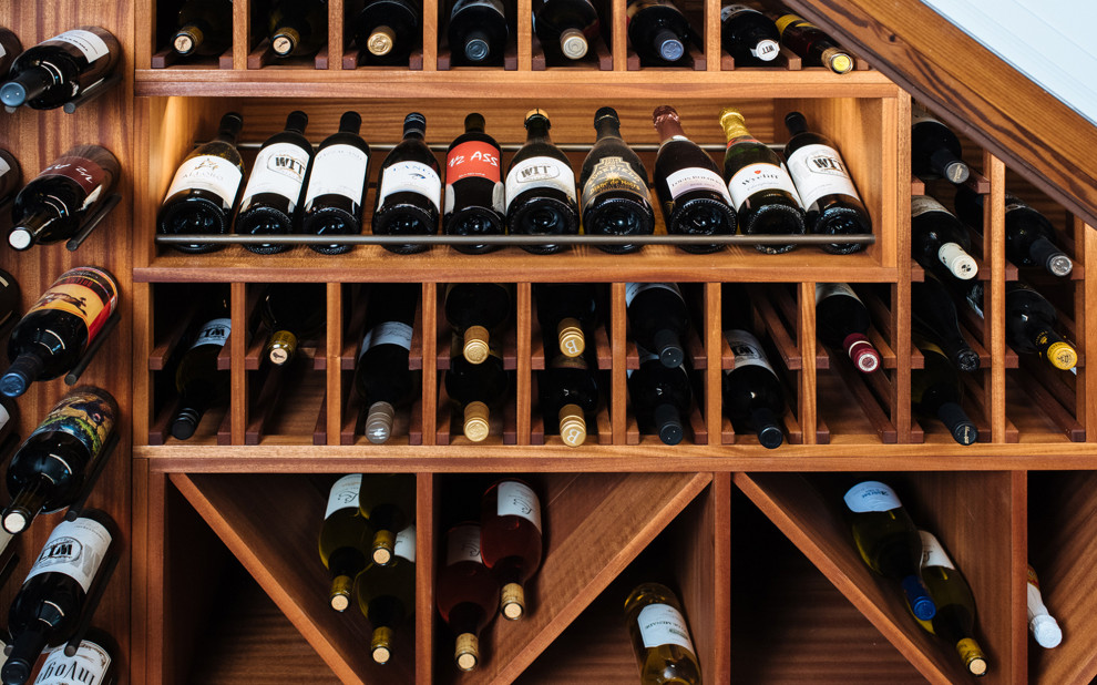 This is an example of a small traditional wine cellar in Portland with dark hardwood floors, storage racks and brown floor.