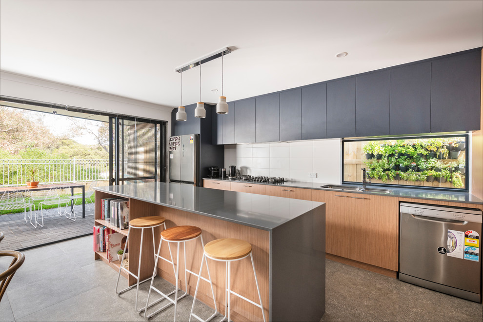 This is an example of a mid-sized contemporary galley open plan kitchen in Perth with an undermount sink, open cabinets, light wood cabinets, quartz benchtops, white splashback, cement tile splashback, stainless steel appliances, ceramic floors, with island, grey floor and grey benchtop.