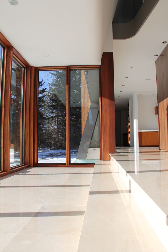 Photo of a contemporary foyer in Toronto with limestone floors, a single front door and a medium wood front door.