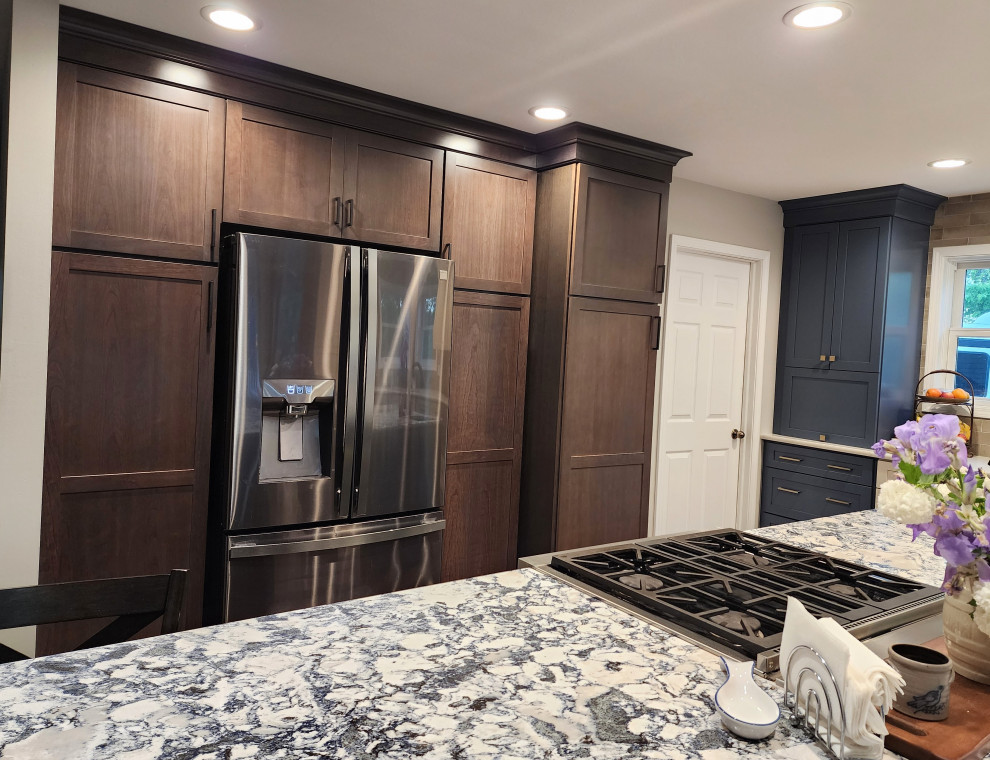 Large country l-shaped medium tone wood floor and gray floor eat-in kitchen photo with an undermount sink, shaker cabinets, subway tile backsplash, stainless steel appliances, an island and multicolored countertops