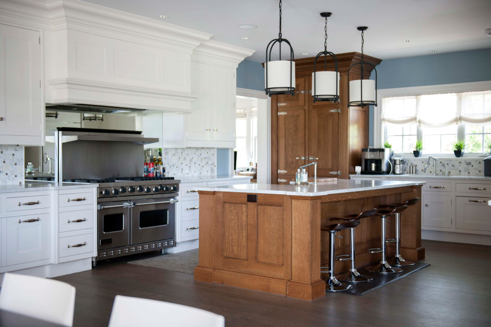 Kitchen - large transitional l-shaped dark wood floor and brown floor kitchen idea in New York with a farmhouse sink, shaker cabinets, white cabinets, gray backsplash, porcelain backsplash, stainless steel appliances, an island and white countertops