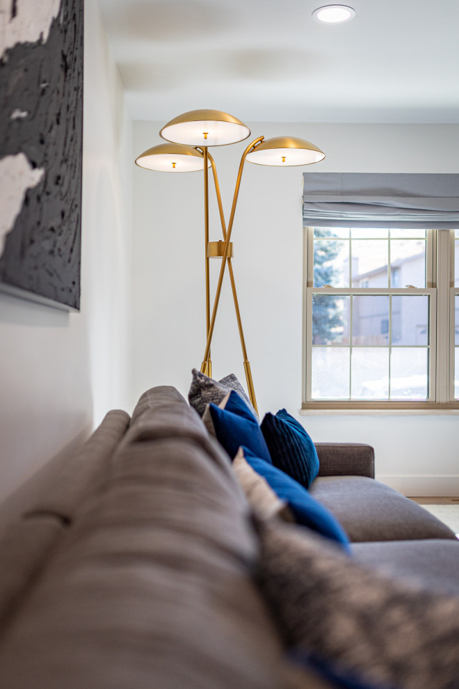 Imagen de sala de estar abierta minimalista extra grande con paredes blancas, suelo de madera clara, todas las chimeneas, marco de chimenea de ladrillo y televisor colgado en la pared