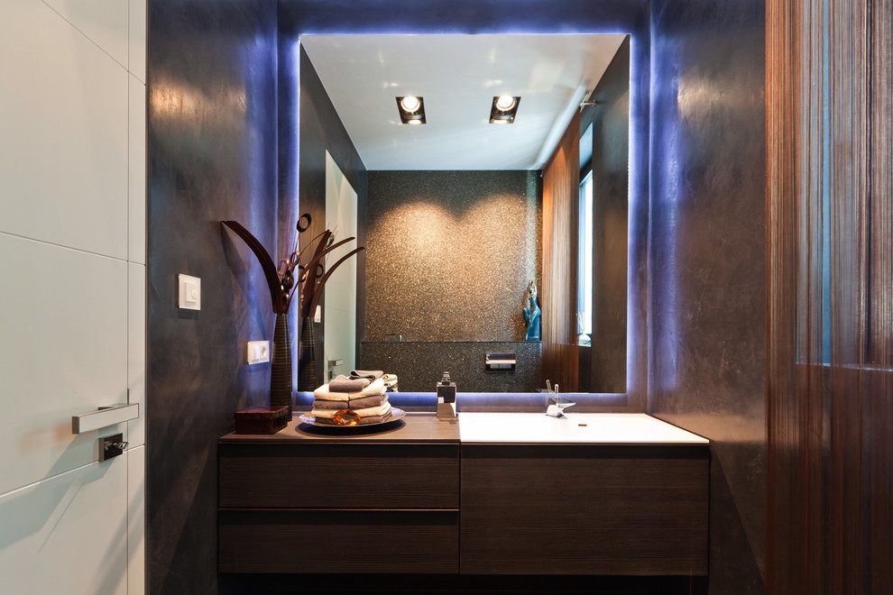Photo of a contemporary powder room in Frankfurt with flat-panel cabinets, a drop-in sink, wood benchtops, brown walls, dark wood cabinets and brown benchtops.