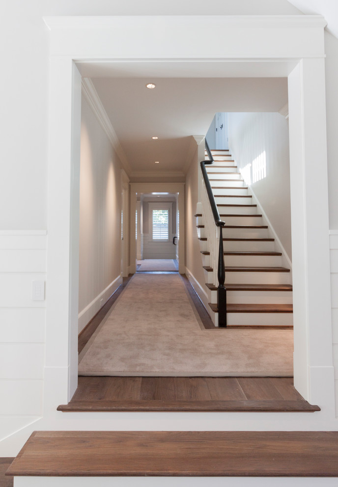 Photo of a large traditional wood straight staircase in DC Metro with wood risers and wood railing.