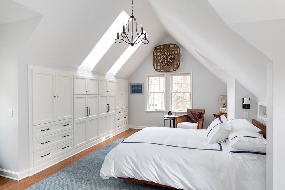 Imagen de dormitorio principal y abovedado tradicional renovado grande con paredes blancas, suelo de madera en tonos medios y suelo marrón