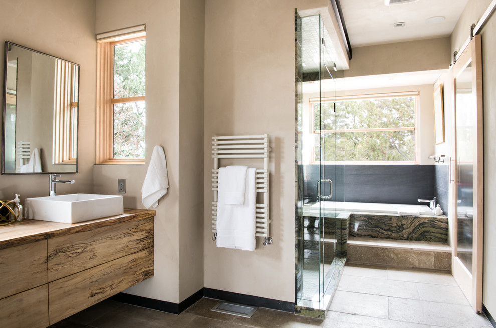 Design ideas for a mid-sized contemporary master bathroom in Other with a vessel sink, flat-panel cabinets, medium wood cabinets, a drop-in tub, beige walls, an alcove shower, gray tile, slate, ceramic floors, wood benchtops, beige floor and a hinged shower door.