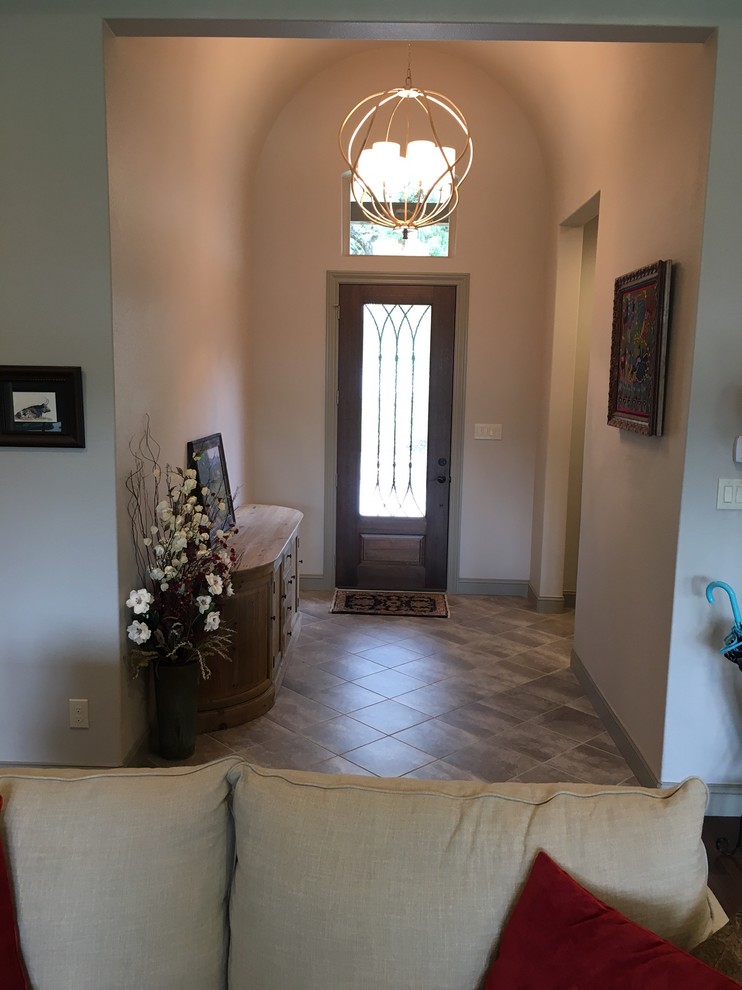 This is an example of a small traditional foyer in Austin with beige walls, porcelain floors, a single front door, a glass front door and grey floor.