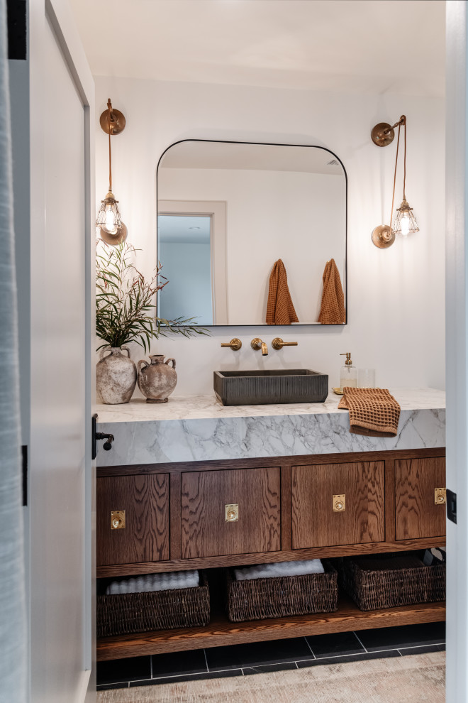 Foto di una stanza da bagno classica con ante lisce, ante in legno bruno, pareti bianche, lavabo a bacinella, pavimento nero, top bianco e un lavabo