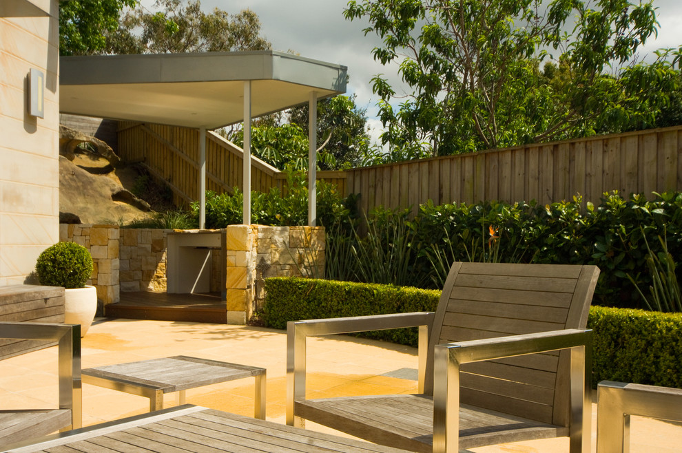 Australian native transitional backyard full sun outdoor sport court in Sydney with natural stone pavers for winter.