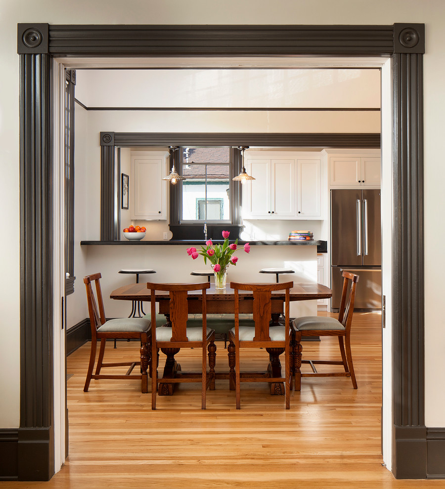 Mid-sized traditional kitchen/dining combo in Santa Barbara with white walls and light hardwood floors.