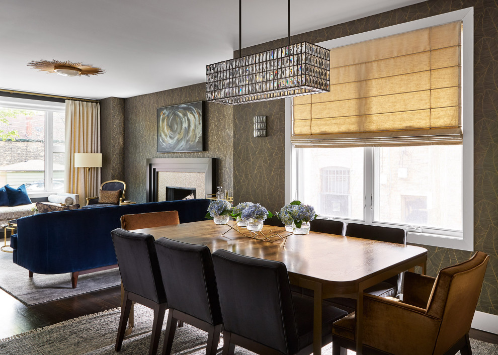 This is an example of a mid-sized transitional open plan dining in Chicago with black walls, dark hardwood floors, a standard fireplace, a tile fireplace surround, brown floor and wallpaper.