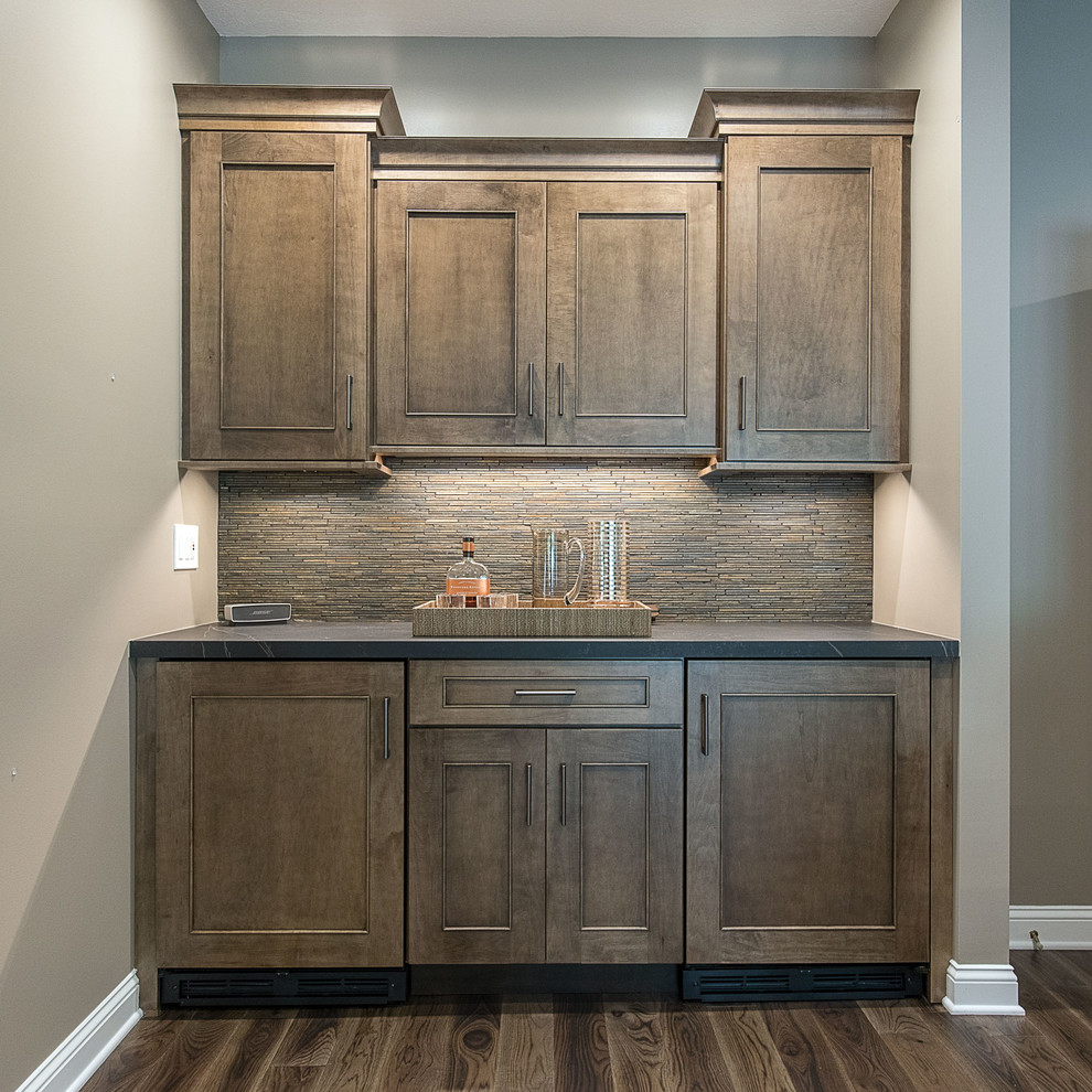 Example of a large transitional l-shaped medium tone wood floor and brown floor eat-in kitchen design with an undermount sink, flat-panel cabinets, dark wood cabinets, marble countertops, white backsplash, ceramic backsplash, stainless steel appliances, an island and white countertops