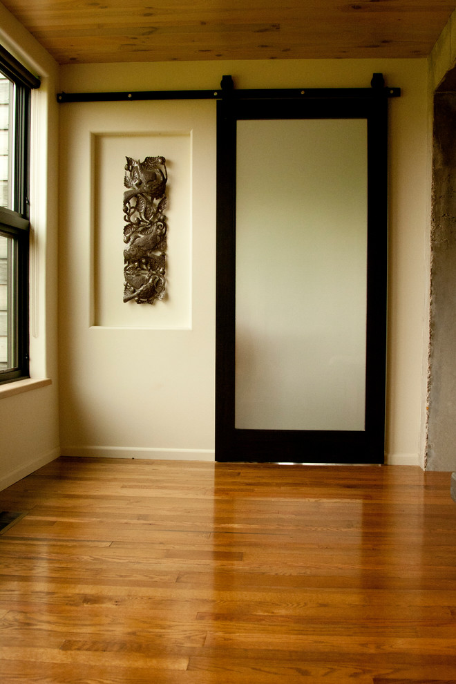 This is an example of a mid-sized modern hallway in Other with white walls, medium hardwood floors and brown floor.