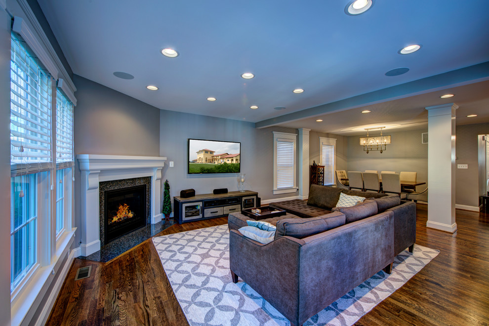 Inspiration for a mid-sized transitional open concept family room in DC Metro with grey walls, medium hardwood floors, a corner fireplace, a stone fireplace surround, a wall-mounted tv and brown floor.