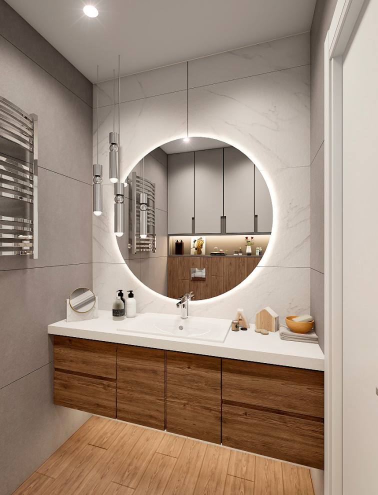 Réalisation d'un petit WC et toilettes avec un mur gris, sol en stratifié, un lavabo encastré, un plan de toilette en surface solide, un sol marron, un plan de toilette blanc et meuble-lavabo suspendu.