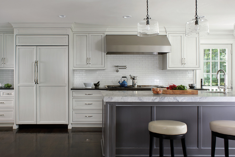 Example of a large transitional u-shaped dark wood floor enclosed kitchen design with shaker cabinets, white cabinets and an island