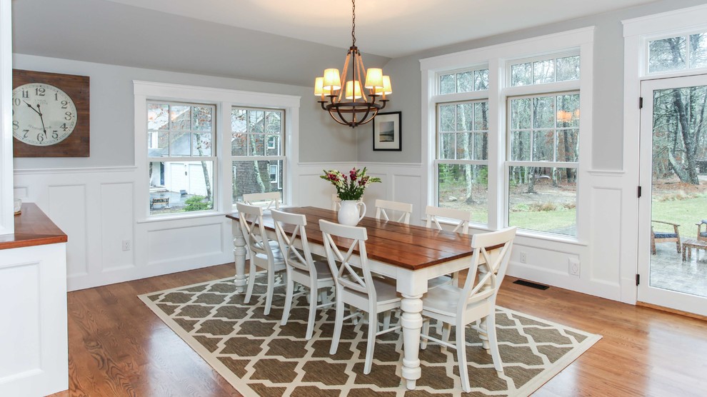 Expansive traditional open plan dining in Other with grey walls and medium hardwood floors.