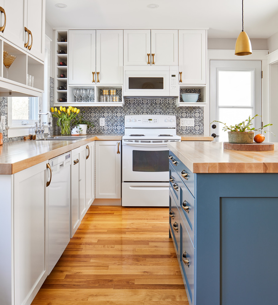 Design ideas for a small transitional l-shaped eat-in kitchen in Ottawa with a drop-in sink, shaker cabinets, blue cabinets, wood benchtops, blue splashback, ceramic splashback, white appliances, medium hardwood floors and with island.
