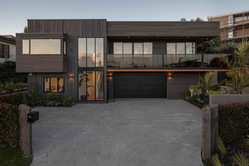 Inspiration for a contemporary two-storey brown house exterior in Auckland with wood siding.