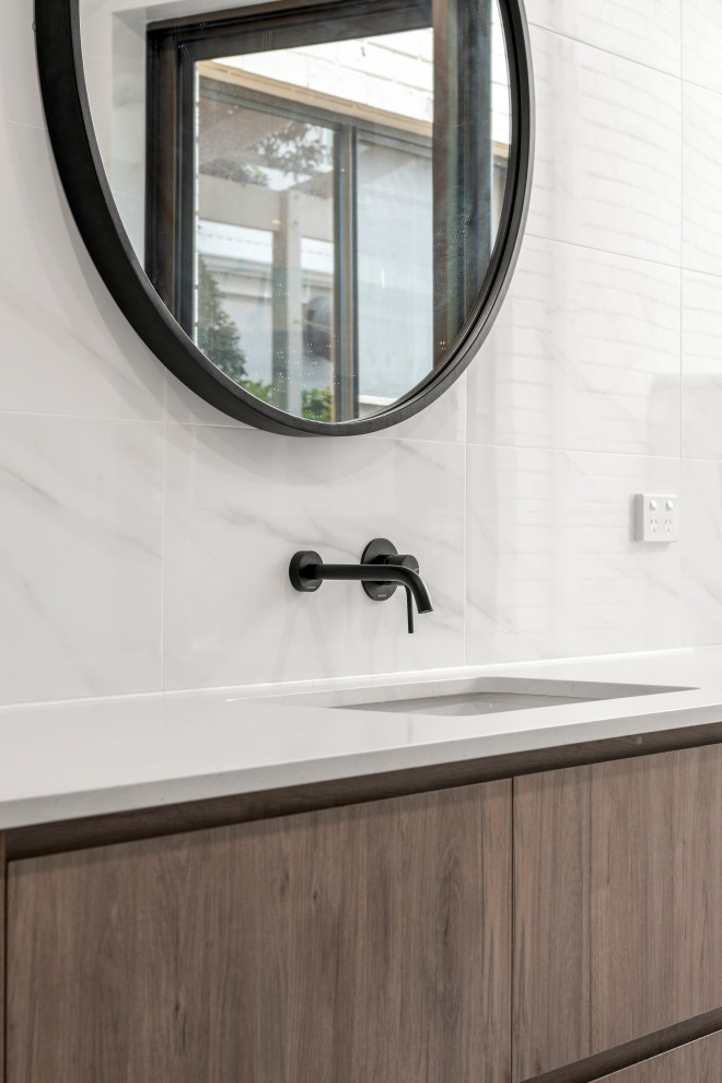 Design ideas for a modern 3/4 bathroom in Perth with shaker cabinets, medium wood cabinets, a corner shower, a one-piece toilet, white tile, ceramic tile, white walls, ceramic floors, an undermount sink, grey floor, an open shower and white benchtops.