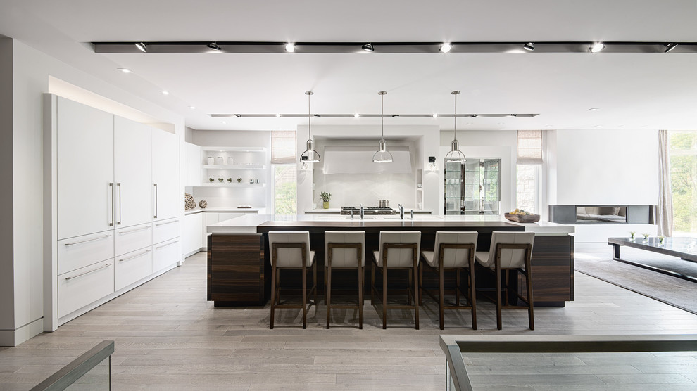 Design ideas for a large contemporary l-shaped open plan kitchen in Sydney with an integrated sink, white cabinets, light hardwood floors, with island and brown floor.