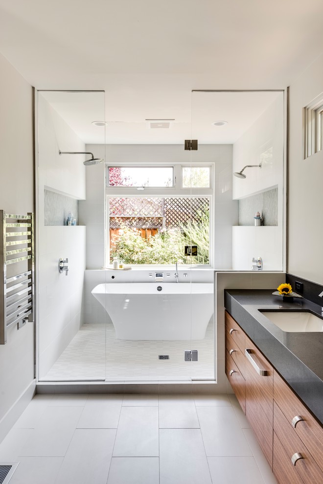 Photo of a large contemporary master wet room bathroom in San Francisco with flat-panel cabinets, medium wood cabinets, a freestanding tub, white walls, ceramic floors, an undermount sink, a hinged shower door, engineered quartz benchtops, grey floor and black benchtops.