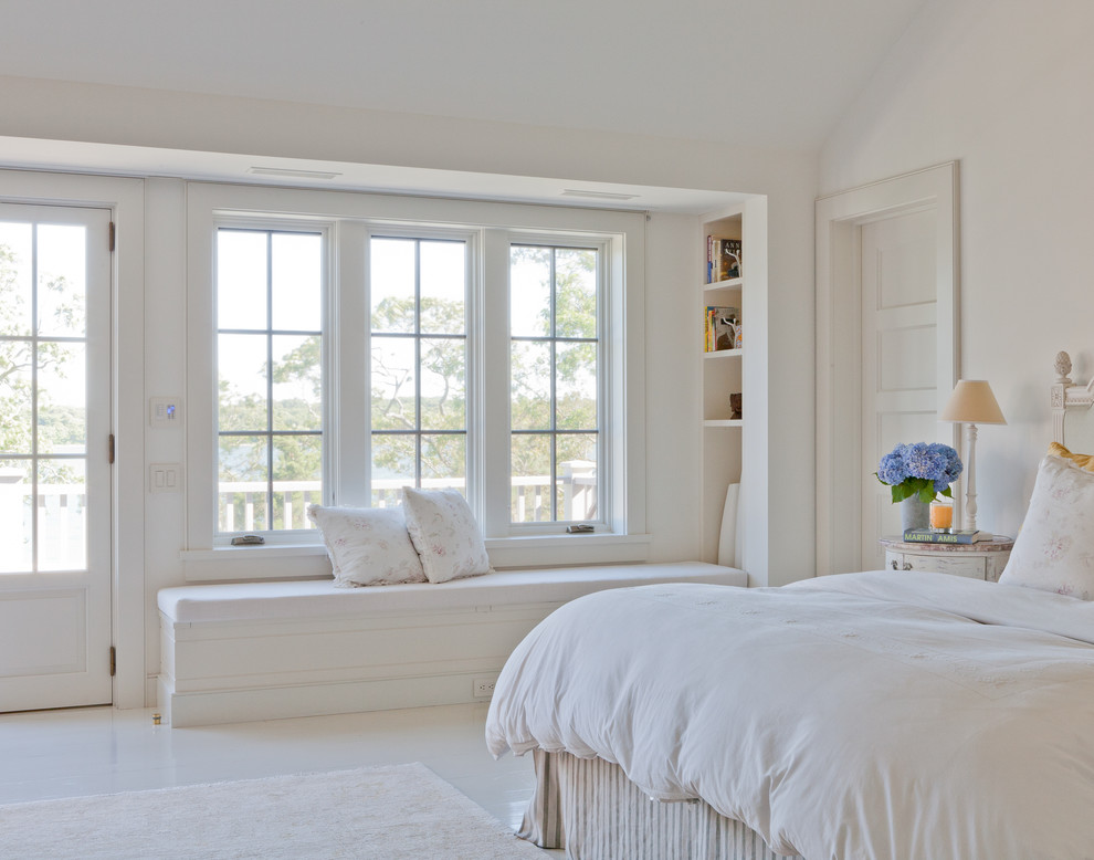 This is an example of a beach style bedroom in New York with white walls and white floor.