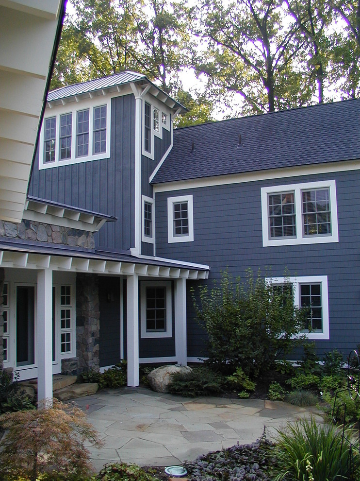 Photo of a large transitional three-storey blue exterior in Detroit with wood siding and a gable roof.