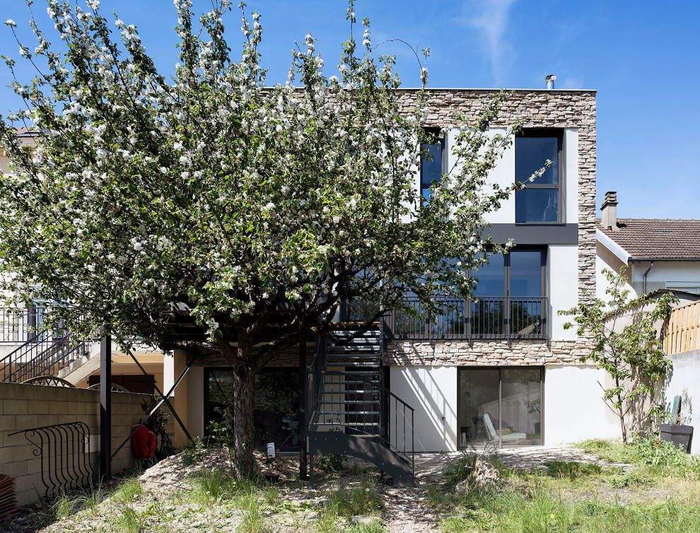 Источник вдохновения для домашнего уюта: огромный, трехэтажный, бежевый дом в современном стиле с облицовкой из цементной штукатурки, плоской крышей и зеленой крышей