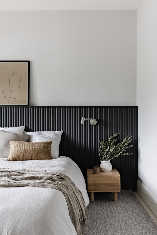 Cette image montre une chambre parentale design avec un mur gris, parquet clair et du lambris.