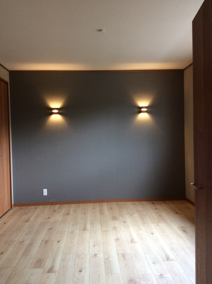 Design ideas for a mid-sized master bedroom in Kyoto with white walls, medium hardwood floors, brown floor and wallpaper.