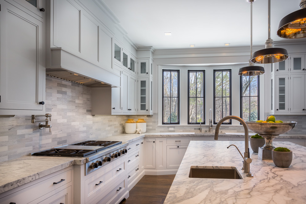 Photo of a large country l-shaped open plan kitchen in New York with an undermount sink, shaker cabinets, grey cabinets, marble benchtops, grey splashback, marble splashback, stainless steel appliances, dark hardwood floors and with island.