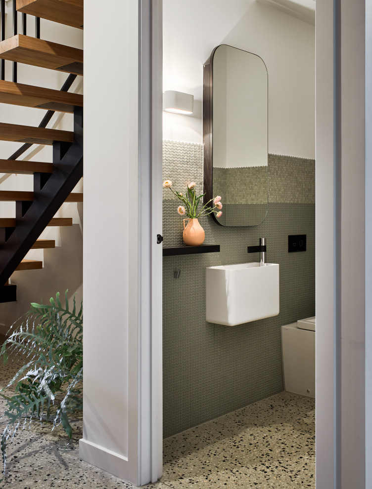 Idée de décoration pour un petit WC et toilettes design avec un carrelage vert, mosaïque, sol en béton ciré, un lavabo suspendu, un sol multicolore et meuble-lavabo suspendu.