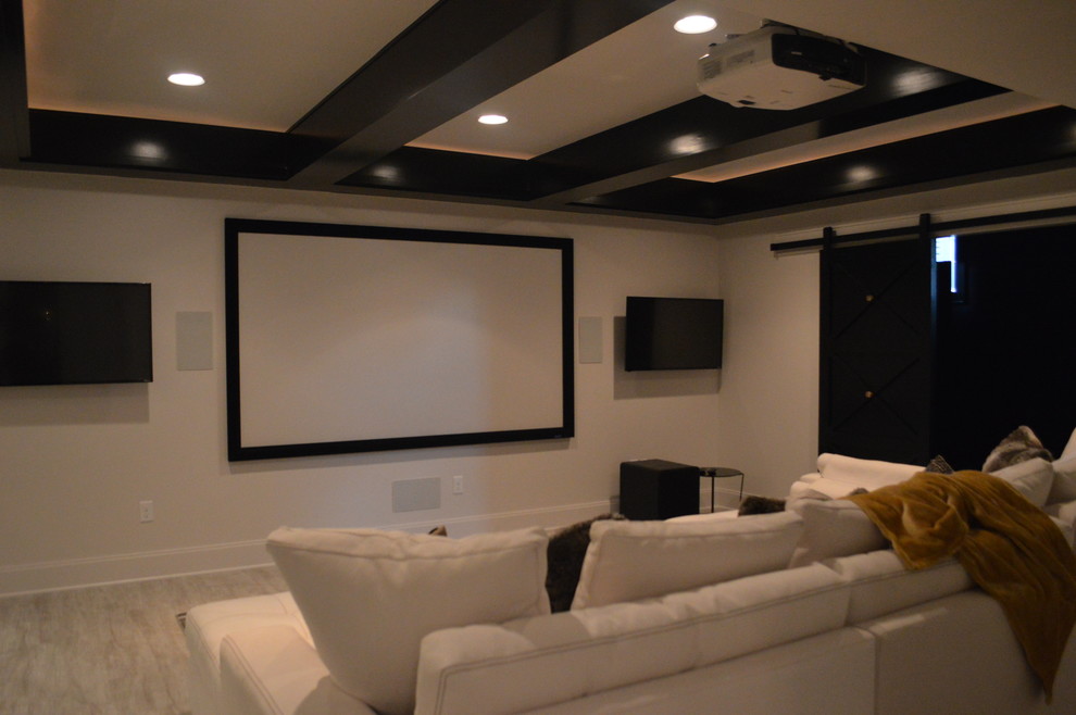 This is an example of a large modern open concept home theatre in Kansas City with white walls, vinyl floors and a projector screen.