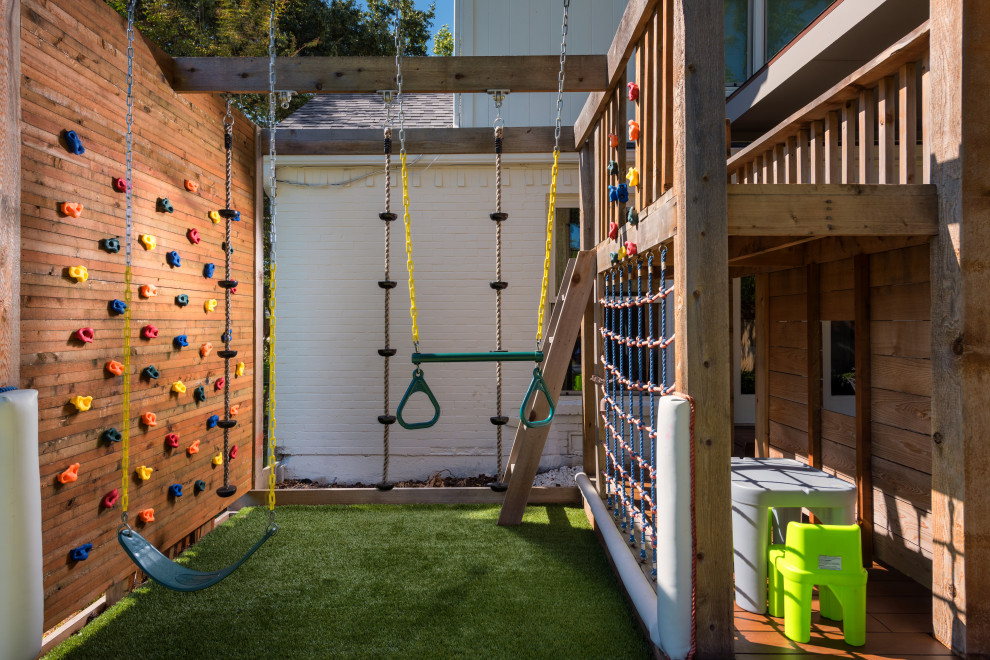 Photo of a mid-sized transitional backyard garden in Dallas with with outdoor playset and decking.