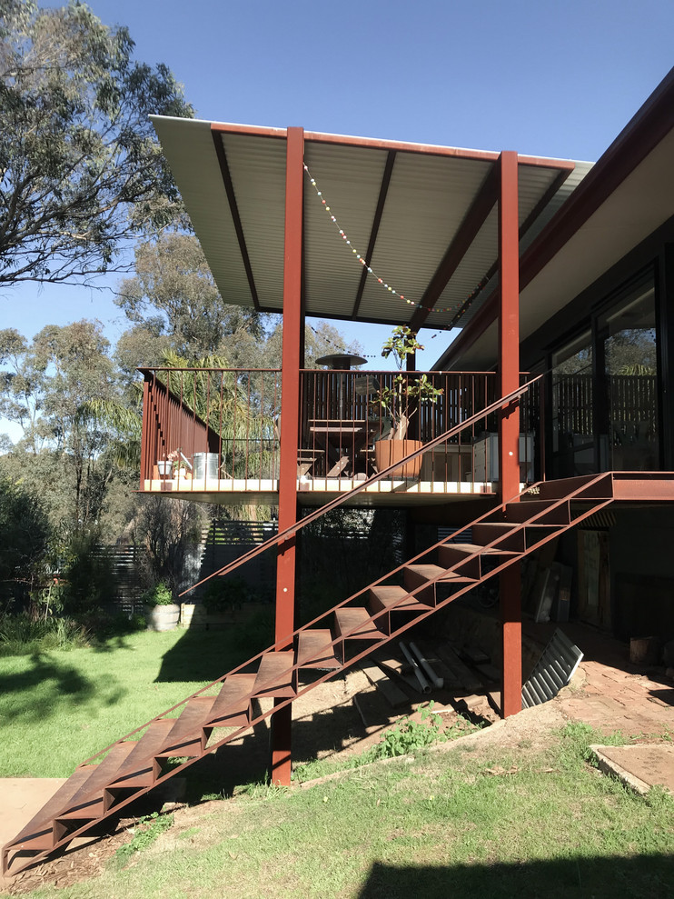 This is an example of a large contemporary backyard deck in Adelaide with a roof extension.