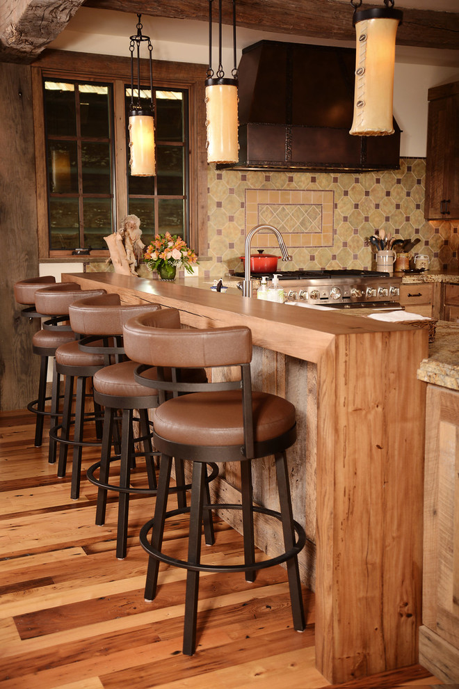 Example of a mid-sized mountain style u-shaped dark wood floor open concept kitchen design with flat-panel cabinets, distressed cabinets, granite countertops, multicolored backsplash, ceramic backsplash, stainless steel appliances and two islands