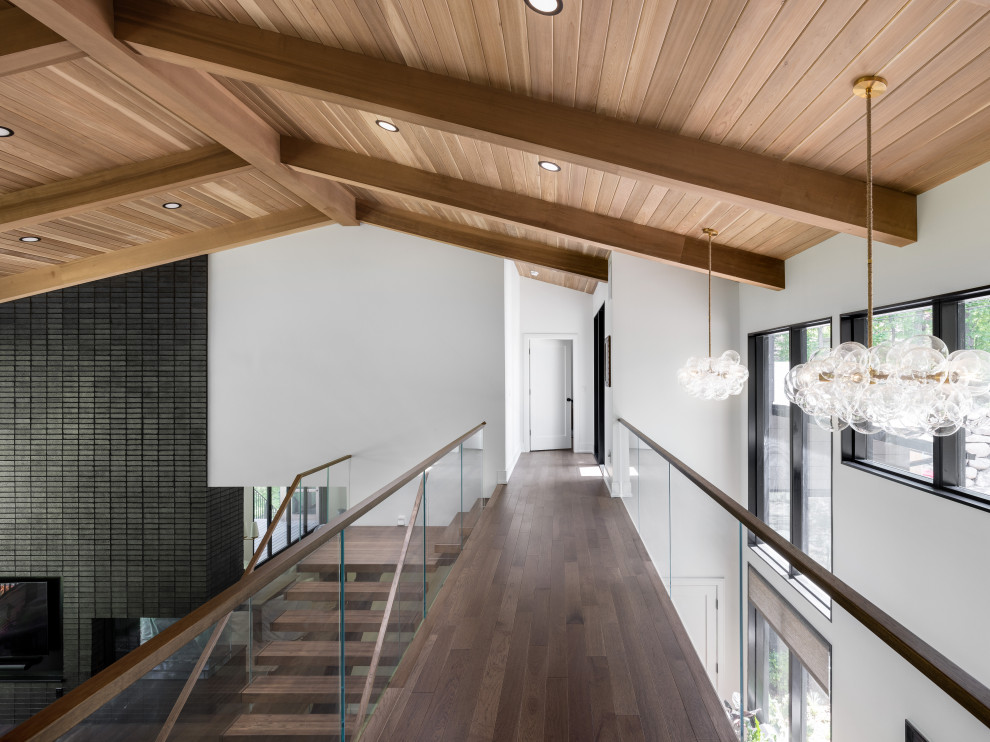 Свежая идея для дизайна: большой коридор в стиле неоклассика (современная классика) с белыми стенами, темным паркетным полом, коричневым полом и деревянным потолком - отличное фото интерьера