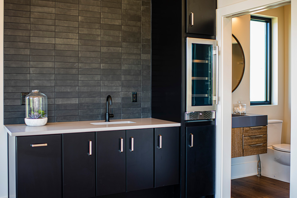Medium sized scandinavian galley dry bar in Indianapolis with a submerged sink, flat-panel cabinets, black cabinets, engineered stone countertops, medium hardwood flooring and white worktops.